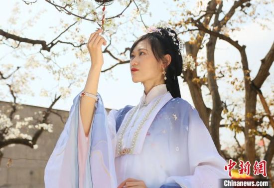 圖為蘭州青年身穿漢服在百年梨園賞景?！「哒?攝