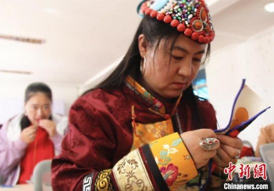 圖為裕固族婦女學(xué)習(xí)刺繡?！∈缝o靜 攝