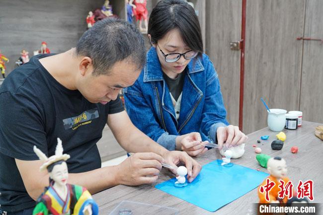 <a target='_blank'  data-cke-saved- >中新社</a>記者(右)現(xiàn)場(chǎng)體驗(yàn)面塑制作過程?！￡悹?zhēng)強(qiáng) 攝