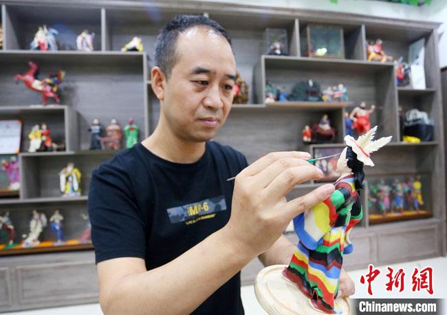 圖為安秋平正在創(chuàng)作代表隴南文縣民俗的《白馬人》作品。　高展 攝