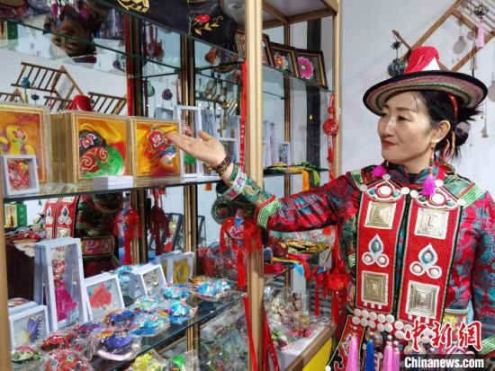 圖為身著民族服飾的隴原巧手展示手工藝品。(資料圖) 徐雪 攝