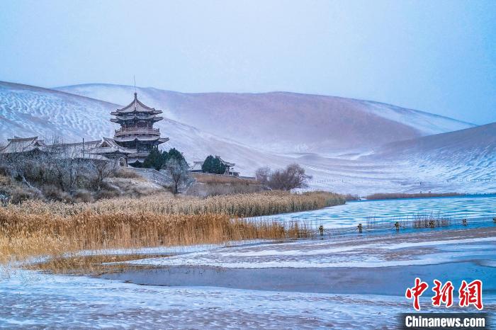 2021年11月28日，雪落鳴沙山月牙泉景區(qū)?！⊥醣筱y 攝