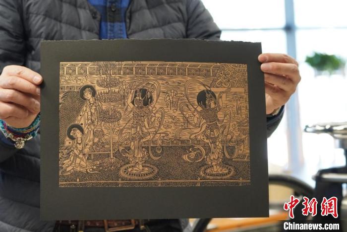 圖為手工書藝人展示敦煌雕版壁畫印刷品?！【琶赖┰?　攝