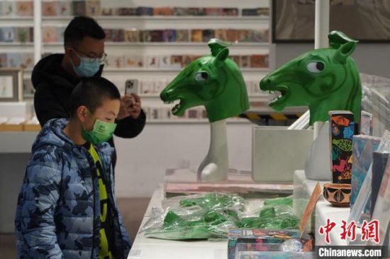 圖為“神馬來了”銅奔馬頭套吸引參觀者駐足?！【琶赖┰?攝