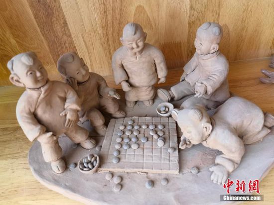 圖為泥塑作品展現(xiàn)下棋場(chǎng)景。 劉玉桃 攝