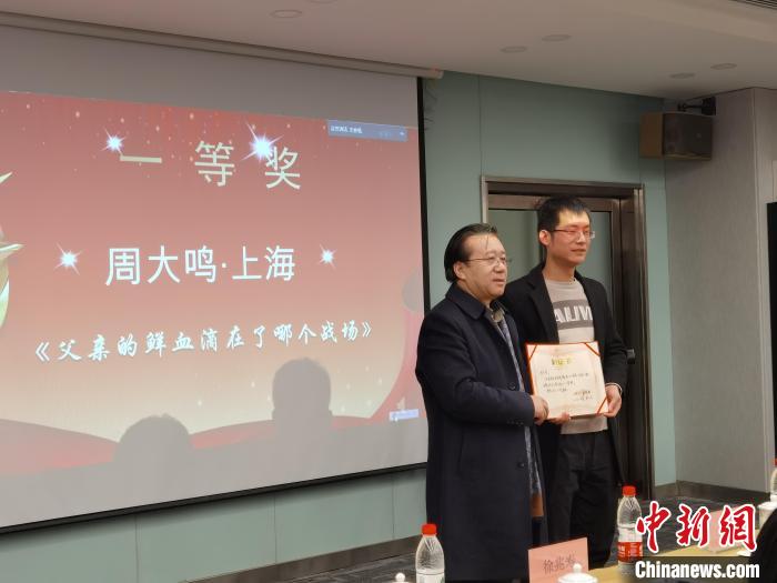 圖為作家、西北師范大學(xué)新聞與傳媒學(xué)院院長徐兆壽頒發(fā)一等獎(jiǎng)證書，代領(lǐng)獎(jiǎng)?wù)呱吓_(tái)領(lǐng)獎(jiǎng)?！钅?攝