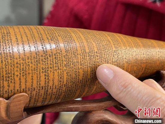 圖為長約二十公分的長條葫蘆雕刻佛教經(jīng)文作品?！堟?攝