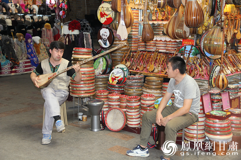 烏魯木齊二道橋巴扎內(nèi)，店主正在向客人展示樂(lè)器。楊文遠(yuǎn) 攝