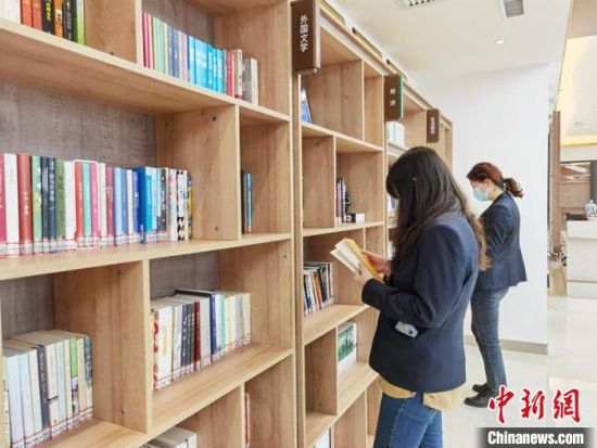 圖為在甘肅公航旅建設(shè)集團(tuán)有限公司的職工書屋，職工挑選書籍?！⌒煅?攝