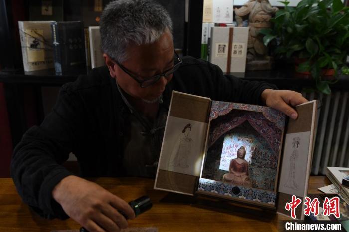 圖為讀者出版集團讀者晉林工作室獨立出品人徐晉林，展示互動性強的敦煌題材手工書。(資料圖) 楊艷敏 攝