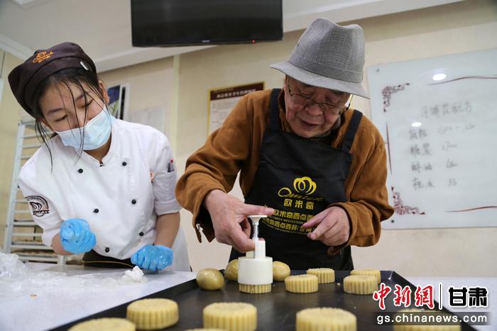 當(dāng)日，受邀參加活動(dòng)的臺(tái)胞臺(tái)屬代表、兩岸婚姻及子女、在甘臺(tái)商代表等歡聚一堂。圖為77歲的在甘臺(tái)胞潘天鑒制作月餅。九美旦增 攝