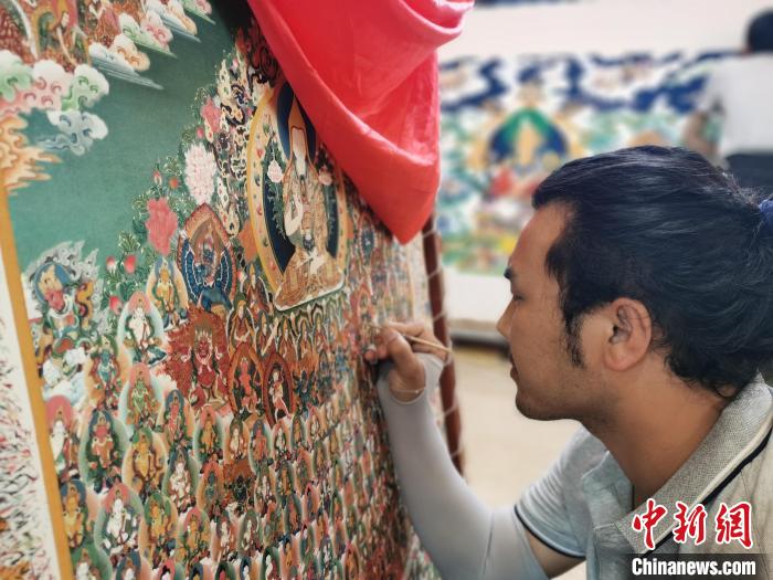 圖為更登才讓的徒弟繪畫唐卡。　張?zhí)砀?攝