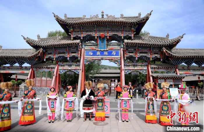 圖為身穿土族服飾的工作人員迎接訪(fǎng)客?！⊙Φ?攝