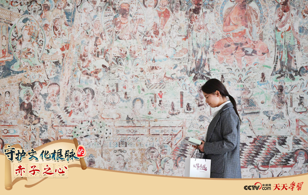2023年4月25日，敦煌研究院文物數(shù)字化保護(hù)團(tuán)隊(duì)創(chuàng)意營(yíng)銷人員廖雪婷從一幅高保真復(fù)制壁畫前走過(guò)。