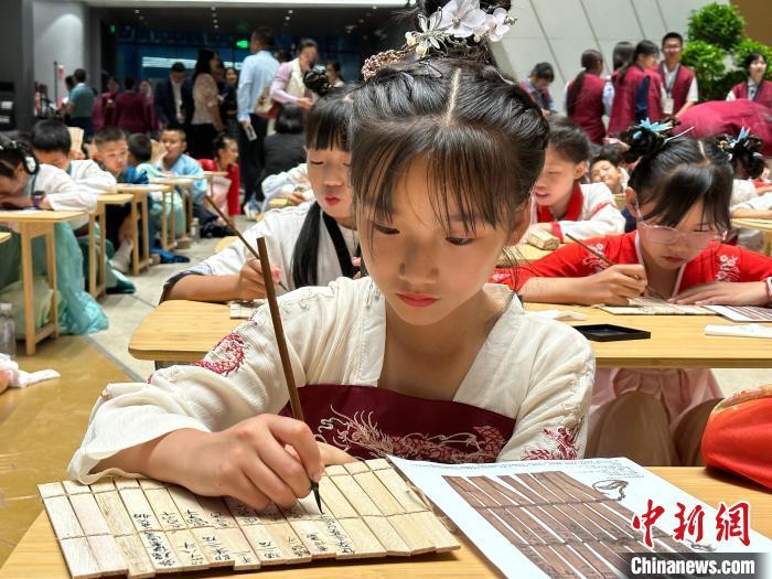 圖為小朋友在甘肅簡牘博物館練習(xí)書法?！≈行律缬浾?戴文昌 攝