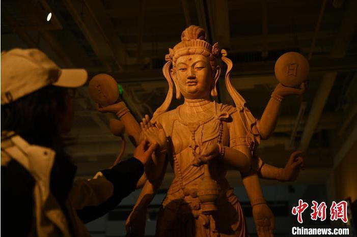 圖為季茂杰觀察自己創(chuàng)作的敦煌木雕。李亞龍 攝</p>
<p>