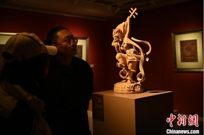 圖為季茂杰向參觀者介紹自己創(chuàng)作敦煌木雕的過程。李亞龍 攝</p>
<p>