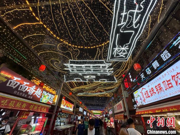 圖為明清街夜市燈光點(diǎn)亮具有武威文化元素的“涼州古城門”彩燈?！〈魑牟?攝</p><p>