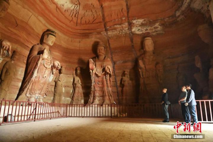 7月15日，游人參觀甘肅省平?jīng)鍪袥艽h百里石窟長(zhǎng)廊中的南石窟寺1號(hào)窟。百里石窟長(zhǎng)廊位于涇川縣境內(nèi)，由512個(gè)石窟、5眼窟中石井組成，現(xiàn)存王母宮石窟、鳳凰山石窟、南石窟寺、丈八寺石窟、羅漢洞石窟、太山寺石窟等規(guī)模較大的石窟群，還有數(shù)量眾多的小石窟群。南石窟寺開(kāi)鑿于北魏永平三年，其中1號(hào)窟屬于大型七佛窟，七佛高達(dá)6米。中新社記者 李亞龍 攝