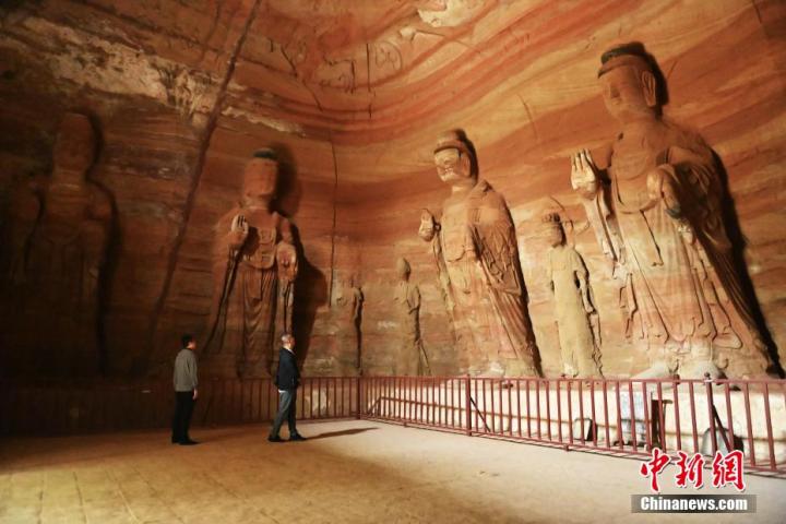 7月15日，游人參觀甘肅省平?jīng)鍪袥艽h百里石窟長(zhǎng)廊中的南石窟寺1號(hào)窟。百里石窟長(zhǎng)廊位于涇川縣境內(nèi)，由512個(gè)石窟、5眼窟中石井組成，現(xiàn)存王母宮石窟、鳳凰山石窟、南石窟寺、丈八寺石窟、羅漢洞石窟、太山寺石窟等規(guī)模較大的石窟群，還有數(shù)量眾多的小石窟群。南石窟寺開(kāi)鑿于北魏永平三年，其中1號(hào)窟屬于大型七佛窟，七佛高達(dá)6米。中新社記者 李亞龍 攝